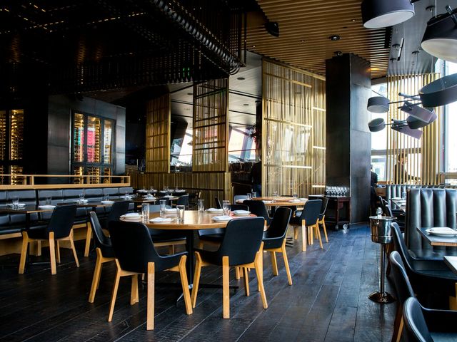 A restaurant dining room with wooden tables and warm lighting
